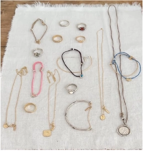 Detailed collection of vintage S925 silver and gold jewelry on a white linen cloth