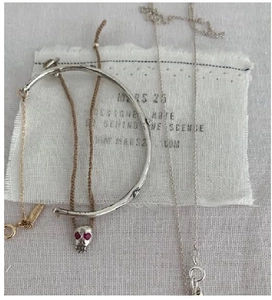 Flat lay of vintage S925 silver bracelet and gold chain necklace on textured fabric