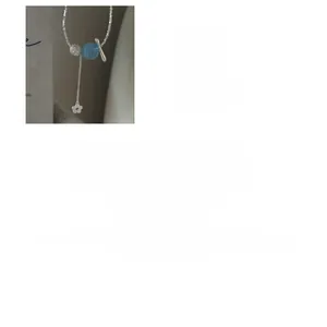 Détail du collier de perles en argent S925 avec sphère bleue et pendentif fleur