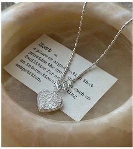 Close-up of S925 sterling silver heart necklace with intricate vintage hollow-out textures
