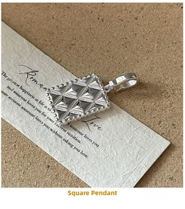 Detail of S925 sterling silver geometric pendant with starburst texture on vintage paper