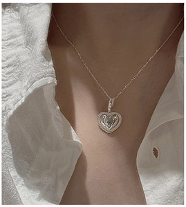 Gros plan d'un pendentif cœur en argent S925 avec bordure perlée sur une chaîne fine