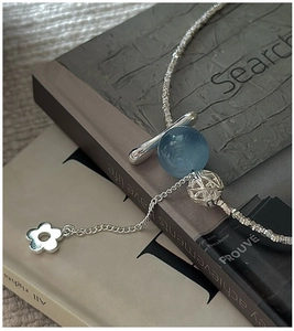 Détail d'une chaîne en argent S925 avec pierre aigue-marine bleue et pendentif fleur