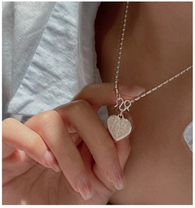 Close-up of S925 sterling silver heart necklace with retro engraved vine textures