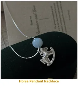 Dettaglio ciondolo cavallo a dondolo S925 con perla blu su velluto nero