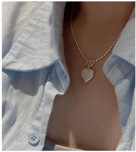 Macro shot of an S925 sterling silver heart pendant with vintage scroll textures