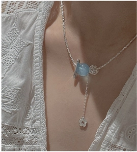 Détail du collier en argent S925 avec perle bleu clair et petit pendentif fleur