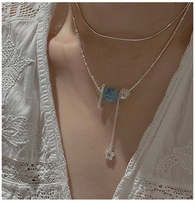 Détail du collier S925 en argent à double rang avec perles bleues et pendentif fleur