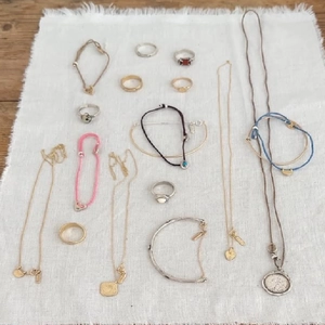 Collection of S925 sterling silver retro bracelets and rings on white fringed linen fabric