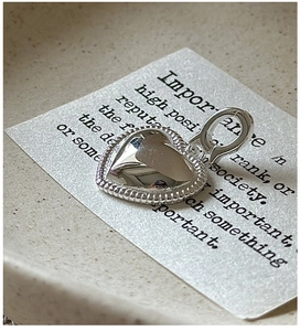 Gros plan d'un pendentif cœur en argent avec bordure perlée et finition polie
