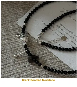 Detail of S925 silver heart tag and black bead necklace on vintage background