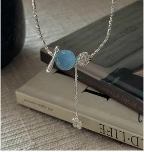 Détail du collier en argent S925 avec une pierre bleue et pendentif fleur délicat