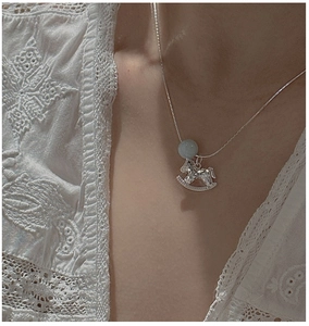 Dettaglio della collana a cavallo a dondolo in argento con gemma blu sul modello