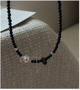 Macro shot of S925 silver beaded necklace with black onyx beads and carved silver pendants