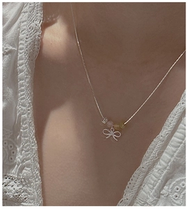 Close-up of S925 silver bow necklace with colorful beads on model collarbone