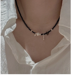 Detail of S925 silver necklace with black agate beads and hollow pendant on a model