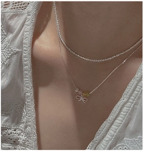 Detail of S925 silver double layer necklace with bow pendant and colored beads