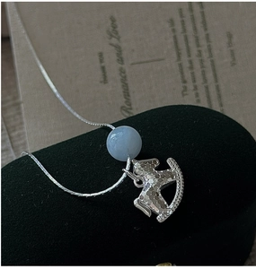 Dettaglio del ciondolo a cavallo a dondolo in argento S925 con perla blu e trama a nido d'ape