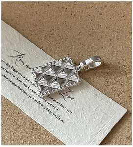 Macro detail of S925 sterling silver geometric pendant with faceted texture and micro-beads