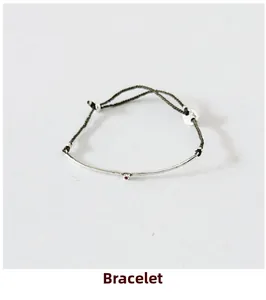 Detailed view of S925 silver twig bracelet with red zircon and dark grey woven cord