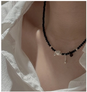 Close-up of S925 silver necklace with black agate beads and vintage metallic pendants