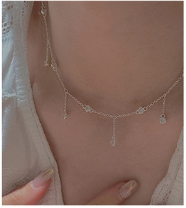 Gros plan d'un collier pampilles en argent S925 avec zircons porté sur le cou