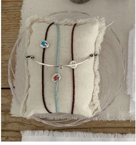 Close-up of S925 silver twig bracelet set with turquoise and coral gemstone charms