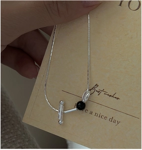 Detail of S925 silver snake chain necklace with black bead and T-bar toggle closure