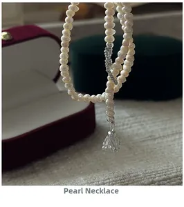 Detailed macro view of S925 silver pearl necklace with lily of the valley floral pendant
