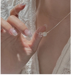 Detail of S925 sterling silver snake chain necklace with crystal bead on white lace dress