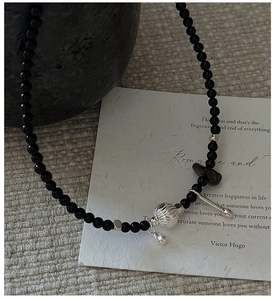 Detail of S925 silver black onyx beaded necklace with textured sphere and droplet charm