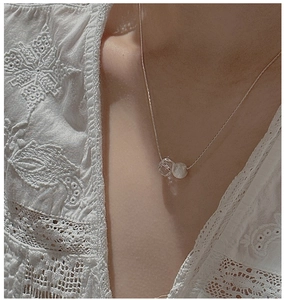 Detail of S925 silver necklace with crystal and matte bead on a female neck model