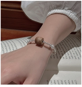 Detail view of S925 silver beaded bracelet with minimalist oval wood bead charm on wrist