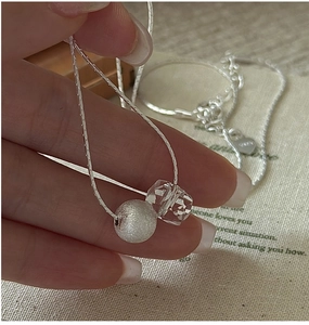 Detail of S925 sterling silver necklace featuring frosted bead and faceted white crystal