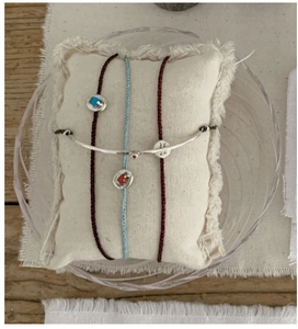 Detail of S925 silver tube bracelet with woven cords and turquoise stone on a mini pillow