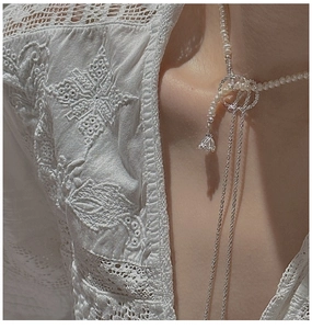 Detail of S925 sterling silver pearl necklace with elegant layered knot and long tassel