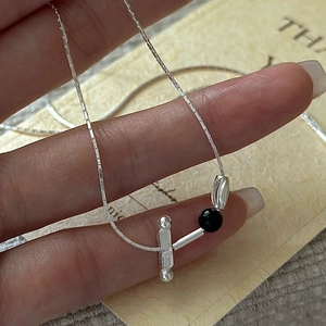 Minimalist S925 sterling silver necklace with black bead and geometric pendant on hand