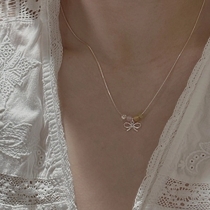 S925 silver necklace featuring a delicate hollow bow pendant with colorful beads on a model