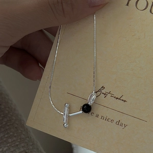 S925 silver necklace with black bead and toggle clasp on decorative card background