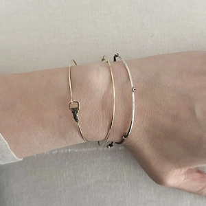 Three-piece stackable bracelet set with gold key charm and silver ruby gemstone bangle