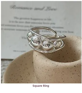 Detail view of a square-shaped 925 sterling silver beaded ring on a ceramic tray