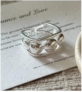 Macro detail of S925 sterling silver beaded open ring on a romantic card backdrop