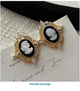 Close-up of vintage cameo earrings with gold metal frame and sparkling crystal inlay