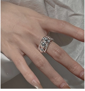 Close-up of S925 sterling silver hollow cage ring with metallic beads on finger
