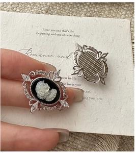Detail of vintage cameo earring featuring silver frame with marquise cubic zirconia stones