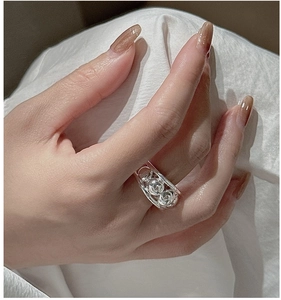 Macro shot of an S925 sterling silver hollow ring with beads on a soft white fabric