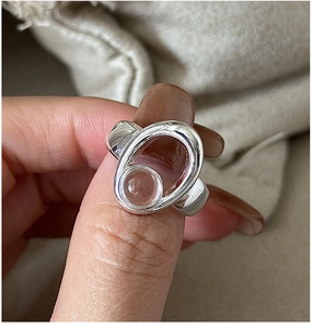 Detail of S925 silver ring featuring hollow oval design and a clear crystal bead