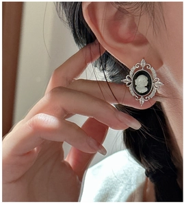 Close-up of S925 sterling silver vintage cameo earrings with rhinestone accents on a model