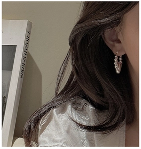 Macro detail of silver croissant hoop earrings with liquid metal textured finish
