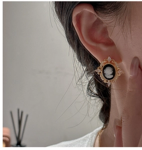 Macro shot of vintage S925 silver cameo earrings with baroque gold frame and zircon details